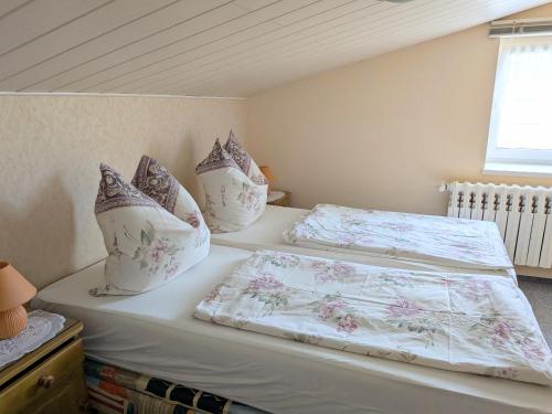 a bedroom with two beds with pillows on them at Zum Häusler-Glück in Biendorf