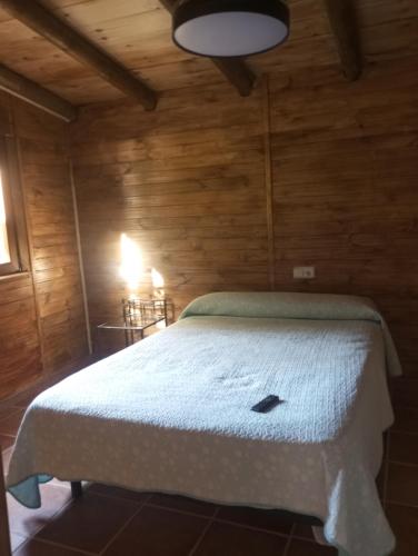 a bedroom with a bed in a wooden room at El guajiro in Mas de las Matas