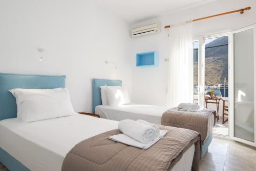 a hotel room with two beds and a balcony at To Steno in Kamares