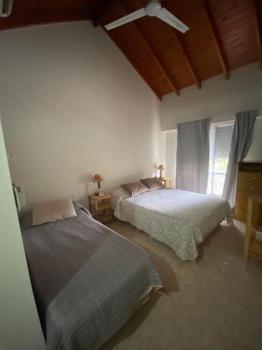 a bedroom with two beds and a ceiling fan at Hostería Amancay in Merlo
