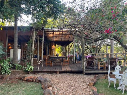 a house with a wooden deck with a table and chairs at Hospedaria do Feno in Brotas