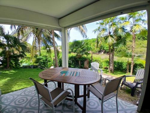 a screened porch with a table and chairs on it at Ti Village Creole in Sainte-Anne