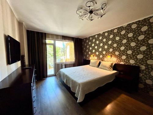 a bedroom with a bed and a window and a chandelier at La Zur Guest House in Ravda