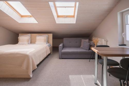 a bedroom with a bed and a chair and a table at Freda Self Check-in in Nida