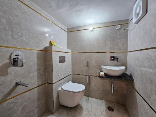 a bathroom with a toilet and a sink at Royal Rani Residency in Ayodhya