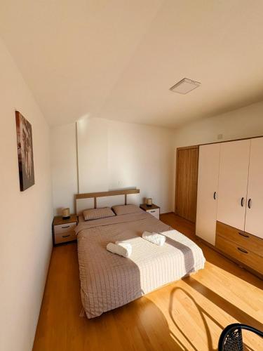 a bedroom with a large bed and wooden floors at Indijano Apartment in Ohrid