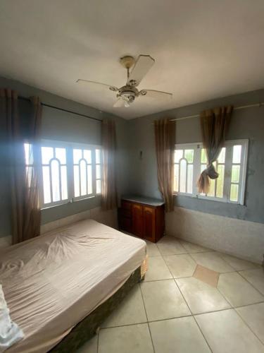 a bedroom with a bed and two windows at Casa Salinas em Salinópolis PA - Completa in Salinópolis