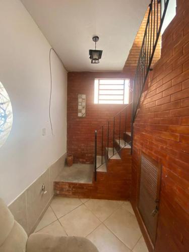 a staircase in a room with a brick wall at Casa Salinas em Salinópolis PA - Completa in Salinópolis
