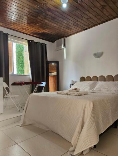 a bedroom with a large bed with a wooden ceiling at Pousada Bem Te Vi Lumiar in Lumiar