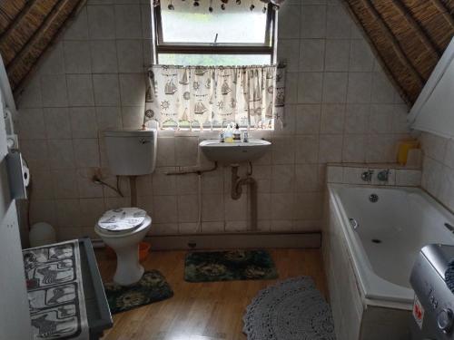 a bathroom with a sink and a toilet and a tub at Vinknes in Boknes