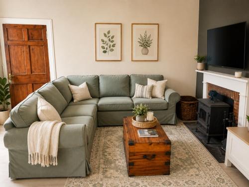 a living room with a couch and a coffee table at Ivy golf cottage in Leven