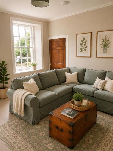 a living room with a couch and a coffee table at Ivy golf cottage in Leven