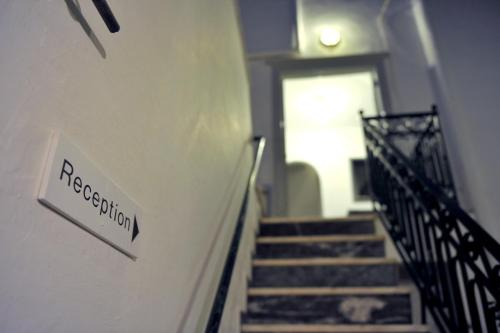a staircase with a sign on the wall of a building at Hydra Icons in Hydra