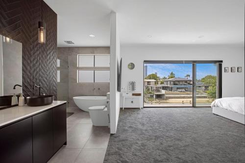 a bathroom with a tub and a sink and a bed at Urban Hideaway - Stay 4 Pay 3 in Gold Coast