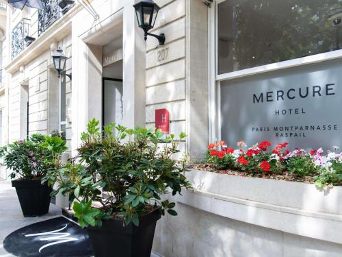 eine Ladenfront mit Blumentöpfen vor einem Geschäft in der Unterkunft Mercure Paris Montparnasse Raspail in Paris