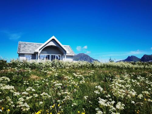 a house on top of a field of flowers at BanPim Beachside Lofoten in Ramberg
