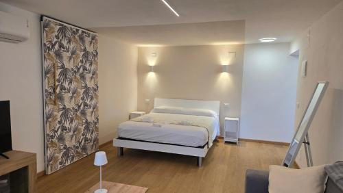 a bedroom with a white bed and a couch at Tiny House in Quarto dʼAltino