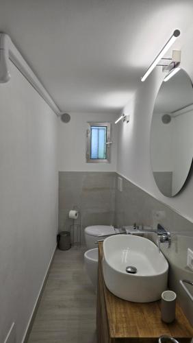 a white bathroom with a sink and a mirror at Tiny House in Quarto dʼAltino