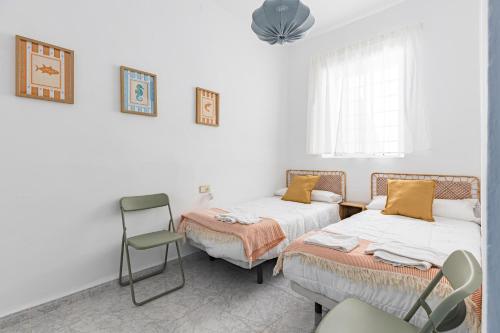 a room with two beds and a chair in it at Casa Marina - Desayuno y parking incluidos in Portman