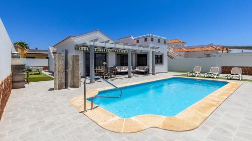a swimming pool in the backyard of a house at Villa with private pool, near beach and golf Caleta de Fuste- Villa Charlotte in Costa de Antigua