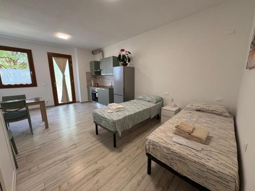 a room with two beds and a kitchen with a table at Riposati e Riparti in San Piero a Sieve