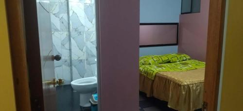 a bedroom with a bed and a sink and a toilet at Hospedaje LA RESIDENCIA in Ayacucho