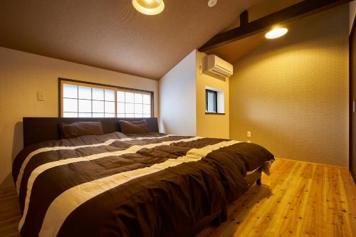 - une chambre avec un grand lit dans une pièce dotée d'une fenêtre dans l'établissement Kyoyado Hakuto, à Kyoto