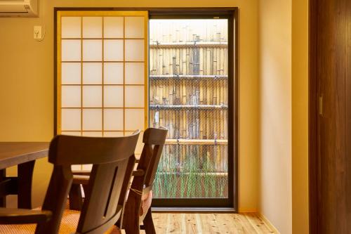 une chambre avec une table, des chaises et une fenêtre dans l'établissement Kyoyado Hakuto, à Kyoto