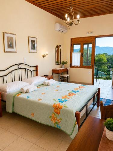 a bedroom with a large bed and a balcony at Epavlis Elena in Konitsa