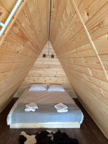 a bed in the middle of a wooden room at Complex turistic Casa Diaconu in Breaza