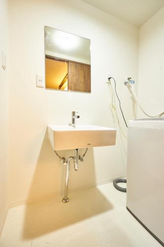 a bathroom with a sink and a mirror at Kyoyado Hakuto in Kyoto