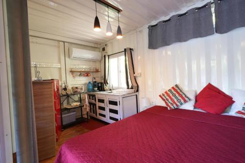 a bedroom with a red bed and a sink at Libertas in Pointe d'Esny
