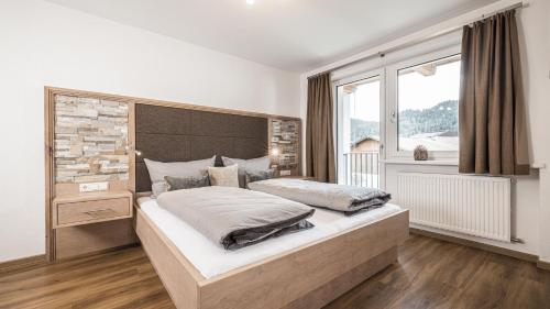 a bedroom with a large bed and a large window at apartments '43 in Reith im Alpbachtal