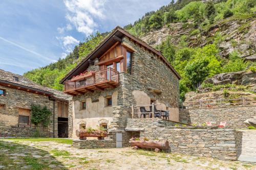 ein Steingebäude mit einem Balkon darauf in der Unterkunft Lo Mayen in Auri Grande