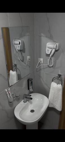a bathroom with a white sink and a mirror at Hotel Santal in Bukhara
