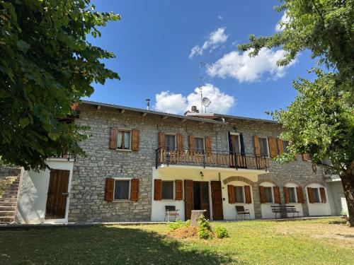 an exterior view of a stone house with a balcony at Casa Vigneto - Villa With Pool in Toano