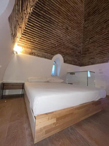 a bedroom with a white bed with a brick wall at The Tower Roma in Rome