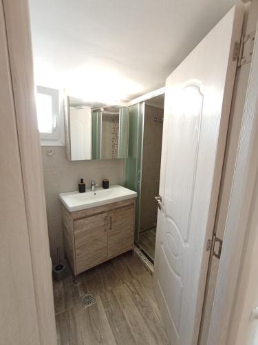 a bathroom with a white sink and a mirror at Kavala Penthouse in Kavála