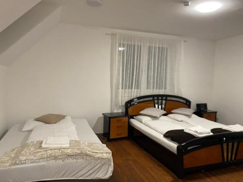 two beds in a small room with a window at Apartment 2 in Neunkirchen