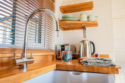 a kitchen with a sink and a counter top with a mixer at Hazel Boutique Shepherds Hut Cotswolds in Cirencester