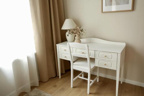 a white desk with a chair and a lamp on it at Center of city apartments, bus station 1min, airport 5 min in Tallinn