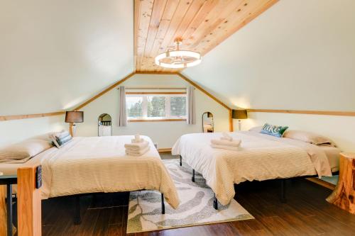 two beds in a room with wooden ceilings at Walk to Flathead Lake! Home w/ Deck & Fenced Yard! in Lakeside