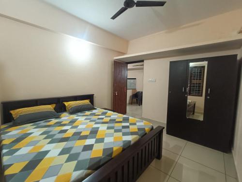 a bedroom with a bed with a checkered blanket at Gokula Arcade in Subrahmanya