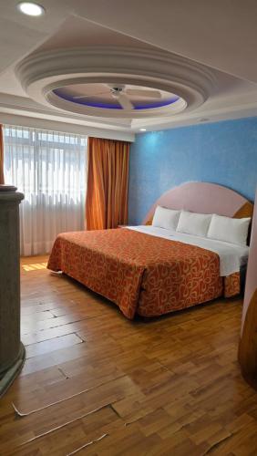 a bedroom with a bed with a blue wall at Hotel Cuba in Mexico City