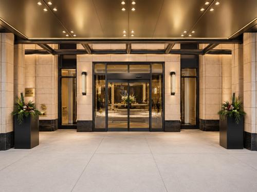 an entrance to a building with two potted plants at Regis Suites - Downtown Toronto in Toronto