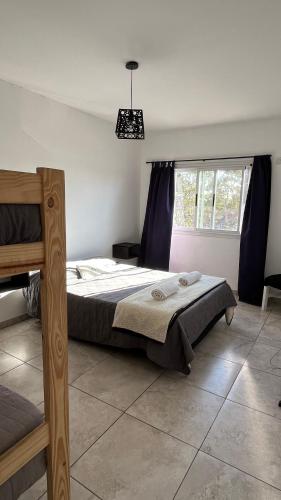 a bedroom with a bed with blue curtains and a window at Travel Suites Ezeiza- 5 pax- Centro Eze- Shoppings a 8 min in Ezeiza