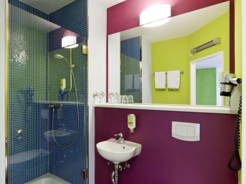 a bathroom with a sink and a shower at ibis Styles Duesseldorf-Neuss in Neuss