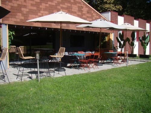 an outdoor patio with tables and chairs and umbrellas at ibis Bourg en Bresse in Bourg-en-Bresse