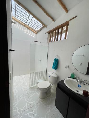 a bathroom with a toilet and a sink and a mirror at Cabaña VillaMaria in Villanueva