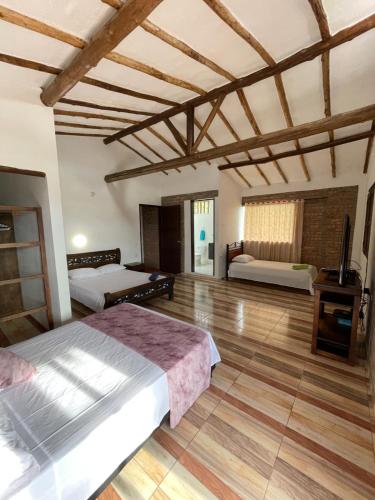 a bedroom with two beds and a wooden floor at Cabaña VillaMaria in Villanueva